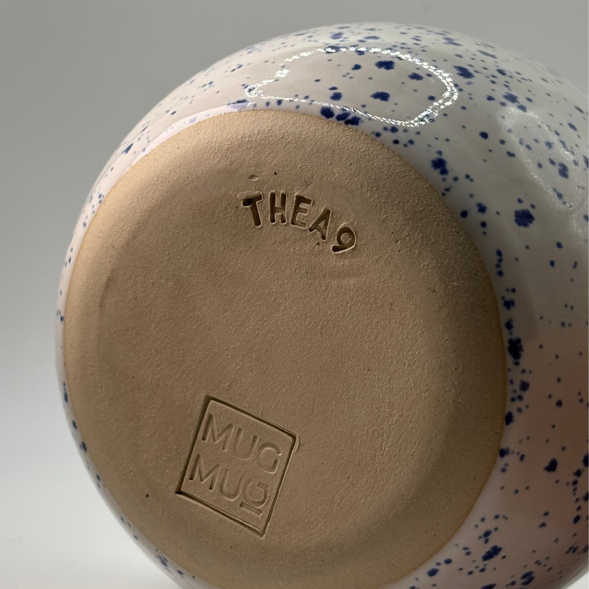 MugMug × THEa9 ceramic matcha bowl with unique blue speckles and spout, designed for whisking L-theanine-rich matcha into a smooth, frothy brew.